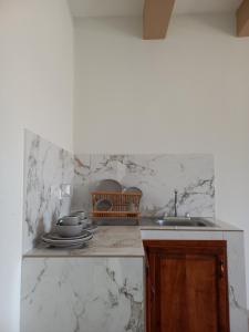 SiguatepequeHotel y Plaza JMI的厨房设有白色大理石墙壁和水槽