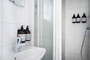 克里斯蒂娜港欧姆普拉斯加德宾馆的浴室设有水槽,配有瓶装葡萄酒