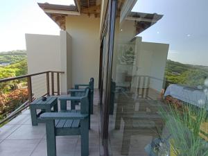 Umhlanga RidgeEkuthuleni Modern Christian Guesthouse with seaview的房屋内的阳台配有桌椅