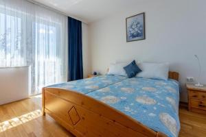 德拉马利Apartments Bozana的一间卧室配有一张带蓝色棉被的大床