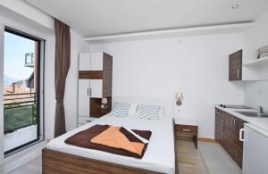 布德瓦Apartments Ivanovic的一间卧室设有一张大床和一个窗户。