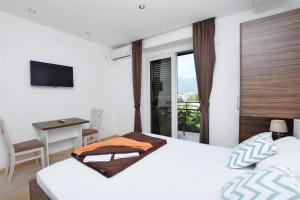 布德瓦Apartments Ivanovic的一间卧室配有一张床、一张书桌和一个窗户。