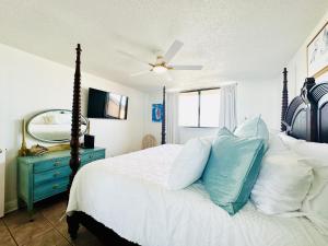 彭萨科拉海滩Gulf Front Penthouse Condo的一间卧室配有一张带蓝色梳妆台和镜子的床