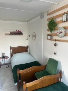DunaszekcsőHet Hongaarse Vissershuisje的一间卧室配有一张床和一把绿色椅子