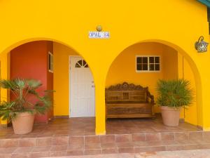 棕榈滩蛋白石之家酒店的黄色的建筑,中间有一张床