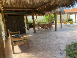 棕榈滩蛋白石之家酒店的一个带草伞和桌椅的庭院