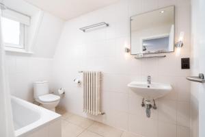 布鲁日Hotel Jacobs的白色的浴室设有水槽和卫生间。