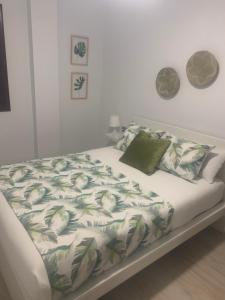 桑卢卡尔-德巴拉梅达Gosol Lemon的一张带绿色和白色毯子及枕头的床