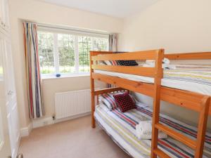 鲍内斯温德米尔Brunton Lodge的一间卧室设有两张双层床和一扇窗户。