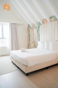 威廉斯塔德Harbor Hotel & Casino Curacao的白色卧室配有一张带白色枕头的大床