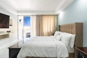 金斯敦City Edge La Vie的卧室设有一张白色大床和一扇窗户。