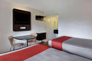 达尼亚滩达尼亚海滩6号汽车旅馆的一间酒店客房,配有一张床铺、一张桌子和一台电视