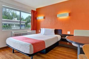 达尼亚滩达尼亚海滩6号汽车旅馆的客房设有床、桌子和窗户。