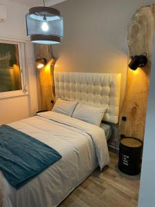 萨卡文Ambientes do Rio Home的卧室配有一张白色的床和大型床头板