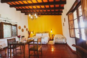 Chicoana芬卡玛格丽特乡村民宿的一间卧室配有两张床和一张桌子及椅子