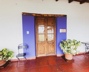 Chicoana芬卡玛格丽特乡村民宿的蓝色的墙壁,设有木门和两把椅子