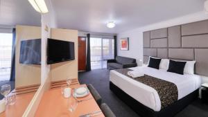 旺加拉塔City Reach Motel的酒店客房设有一张大床和一台电视。