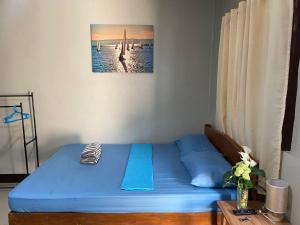 邦劳Alona Bohol Backpackers Hostel的一间位于客房内的蓝色床卧室