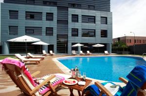马德里纽沃波斯顿酒店的一个带躺椅的游泳池和一间酒店