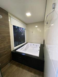 乌巴图巴Trakai Suites的带窗户的浴室设有大浴缸