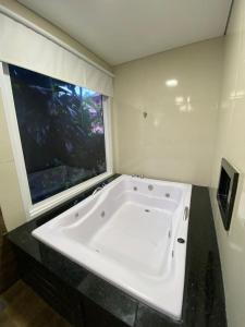 乌巴图巴Trakai Suites的带窗户的浴室内的白色浴缸