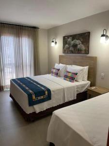 皮雷诺波利斯Suites Quinta Santa Barbara的酒店客房配有一张带枕头的大床