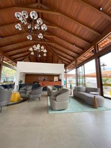 皮雷诺波利斯Suites Quinta Santa Barbara的大楼内客厅配有沙发和椅子