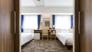 静冈Toyoko Inn Shizuoka eki Minami guchi的酒店客房配有两张床、一张书桌和一张书桌