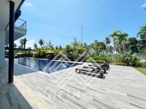 SematanRoxy Sematan Beach Townhouse Deluxe 7 ,8 ,9的毗邻度假酒店的带长椅的游泳池