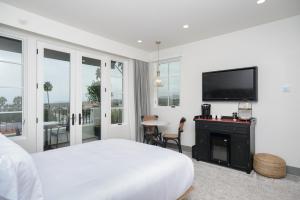 圣克莱门特North Beach Villa的白色卧室配有床和平面电视