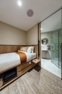 悉尼Aerotel Sydney (Arrivals B, International Terminal 1)的一间卧室设有一张床和一个玻璃淋浴间