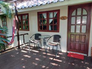 象岛哈雷月亮度假酒店的房屋前设有带2把椅子和1张桌子的庭院。