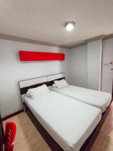美娜多Hotel Riverside Manado的宿舍间的两张床,上面有红色的物体