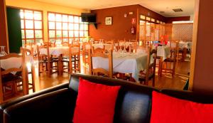 Ontígola帕拉达酒店的用餐室配有桌椅和红色枕头