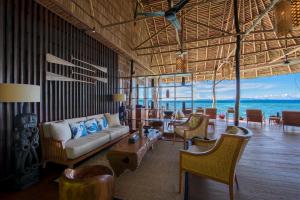 Pulau BiriePapua Paradise Eco Resort的一间带沙发和椅子的客厅,享有海景。