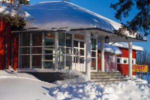 易拉斯加威Ylläs Lake Hotel的一座被雪覆盖的建筑,周围积雪覆盖