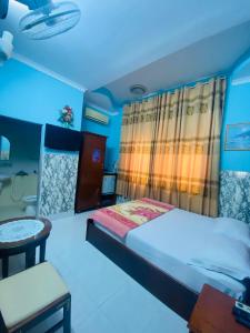 头顿Motel Hoa Hồng的卧室配有1张床、1张桌子和1把椅子