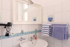 瓦尔内明德Pension Arielle _ Objekt 28014的浴室配有盥洗盆、镜子和毛巾