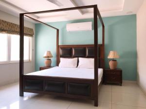 拉瓦尔品第Morgah Resort - Guest Rooms的一间卧室配有一张天蓬床和两盏灯。