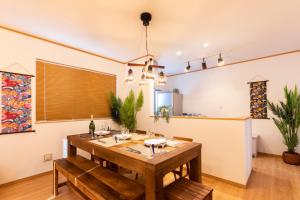 恩纳Y's沖縄リゾートベースNo.1的一间带木桌和椅子的用餐室