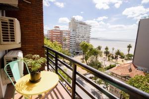 蒙得维的亚Selina Montevideo的阳台配有桌子,享有海景。