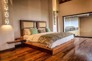 尼甘布Wattura Resort & Spa的一间卧室设有一张大床,铺有木地板