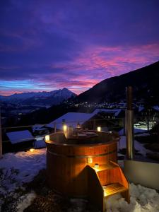 贝阿滕贝格Hotel Fassbind Beausite的晚上在雪地里设有一个热水浴缸