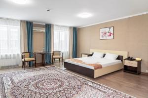 阿斯塔纳阿扎迈特酒店的酒店客房配有一张床铺和一张桌子。