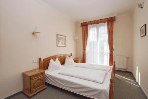 卡罗维发利罗萨别墅酒店的卧室配有白色的床和窗户。