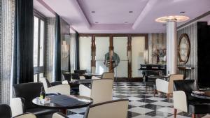马拉加Hotel Larios Málaga的一间带桌椅和钢琴的餐厅
