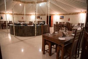 布什格尔Atithi Camp & Resort的一间带桌椅和柜台的餐厅