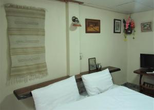 Ban Tha KhoiThe Sunrise Beach Cafe and Guesthouse的卧室配有一张床,墙上挂着一张大海报