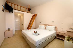 贝尼蔡斯Siora Leni Hotel的一间卧室配有一张带白色床单和梯子的床。