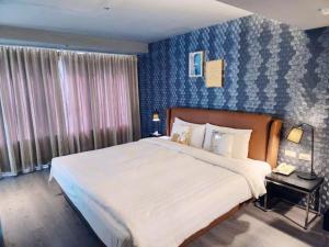 台北安庭台北商旅的一间卧室设有一张大床和蓝色的墙壁